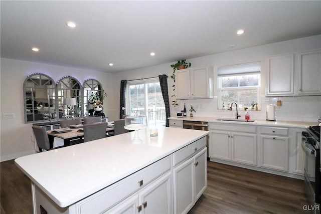 kitchen featuring a kitchen island, white cabinetry, dark hardwood / wood-style flooring, sink, and black range with gas cooktop