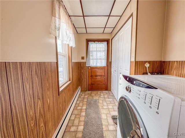 laundry area with baseboard heating, washing machine and clothes dryer, and cabinets