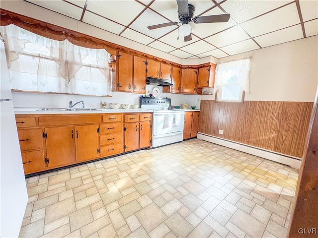 kitchen with wooden walls, a baseboard heating unit, white appliances, a paneled ceiling, and sink