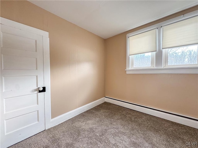 carpeted spare room featuring a baseboard heating unit