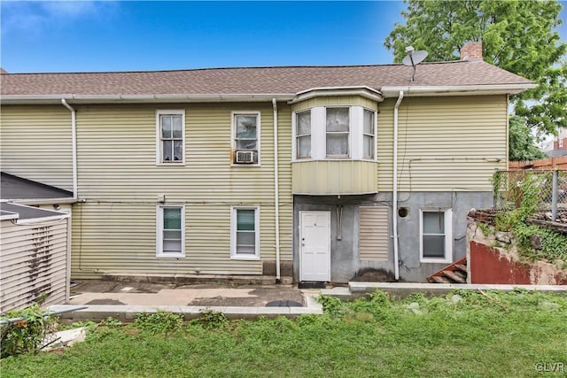 rear view of house featuring cooling unit and a yard