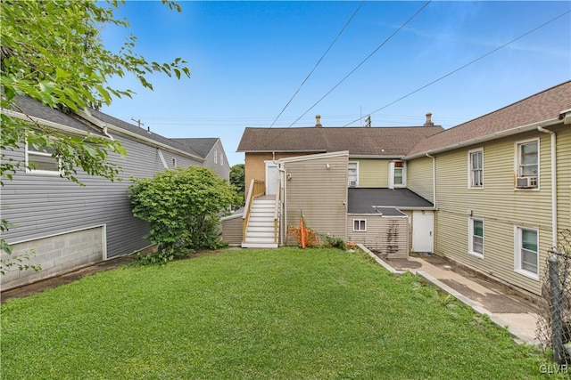 rear view of house featuring a lawn