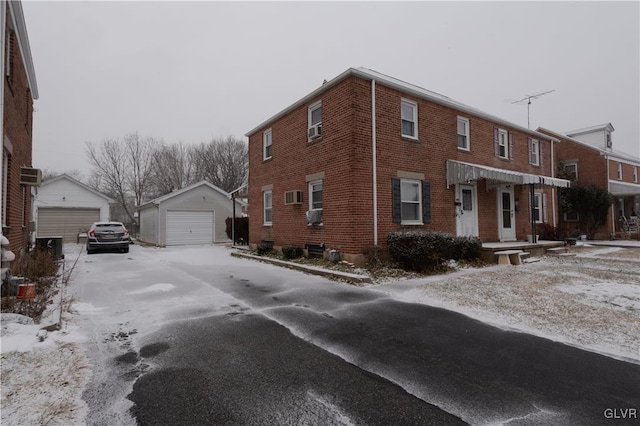 view of snow covered exterior featuring a garage and an outdoor structure