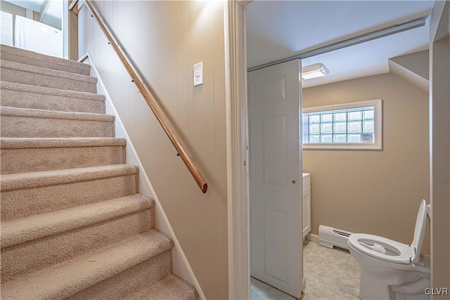 staircase with a baseboard heating unit