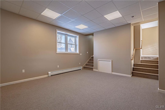 unfurnished room with a paneled ceiling, carpet flooring, and a baseboard radiator