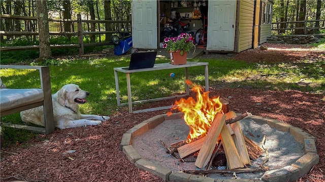 view of yard with an outdoor fire pit and an outdoor structure