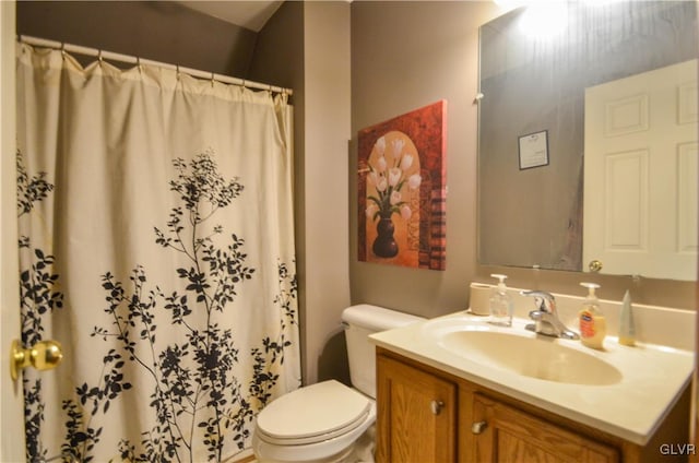 bathroom featuring toilet, vanity, and curtained shower