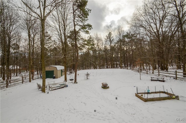 yard layered in snow featuring a shed