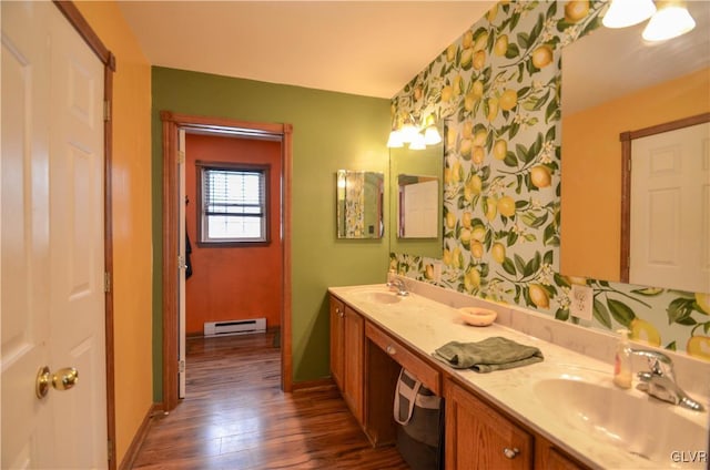 bathroom with hardwood / wood-style flooring, baseboard heating, and vanity