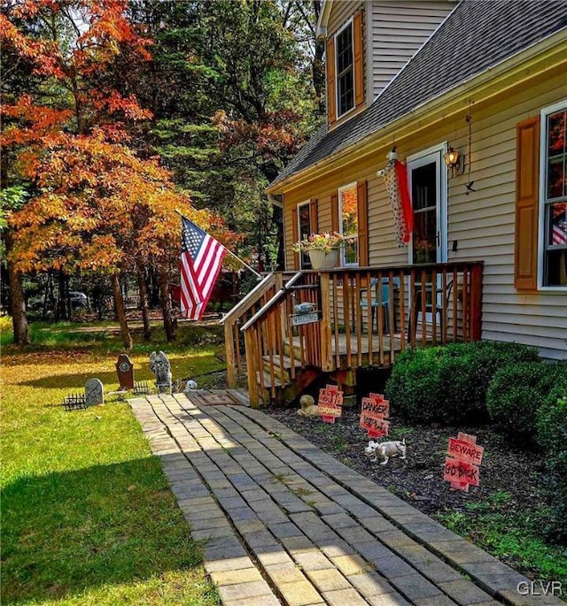 wooden terrace featuring a lawn