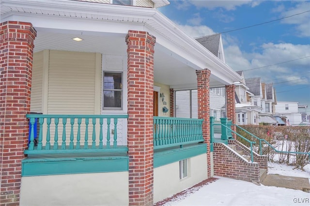 snow covered property featuring covered porch