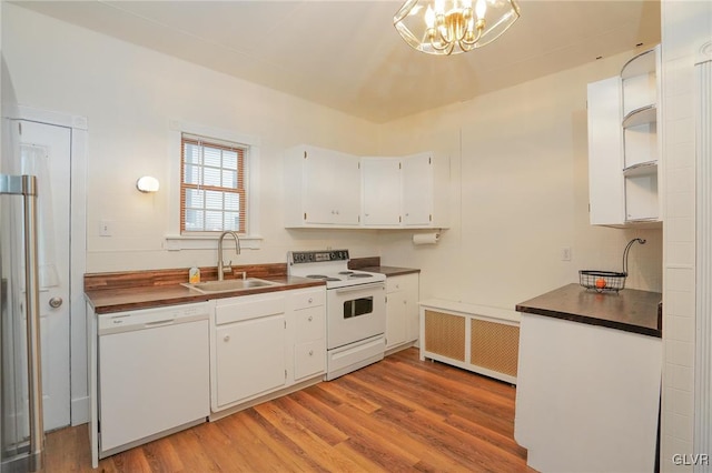 kitchen with white cabinetry, sink, radiator heating unit, and white appliances