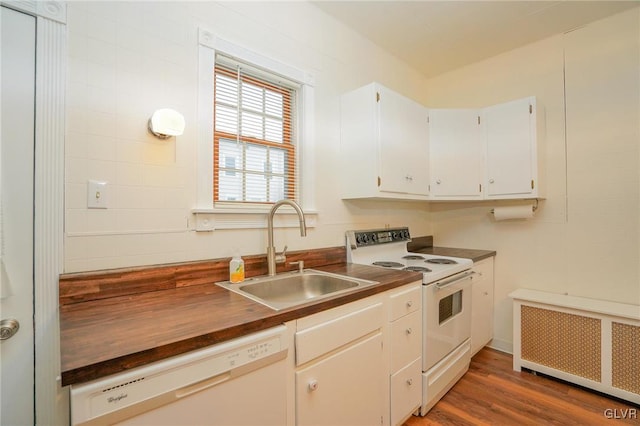 kitchen with white appliances, radiator heating unit, white cabinetry, sink, and dark hardwood / wood-style floors