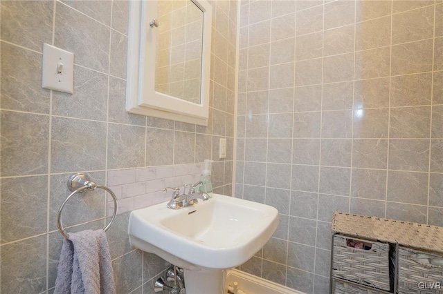 bathroom with tile walls, decorative backsplash, and sink