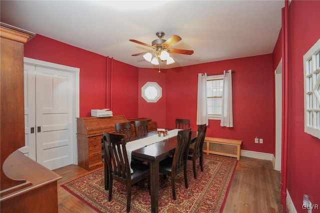 dining space featuring ceiling fan, hardwood / wood-style floors, and radiator