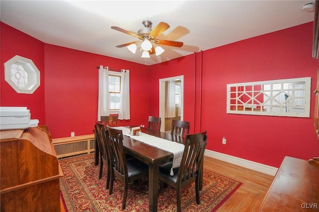 dining area with radiator, ceiling fan, and wood-type flooring