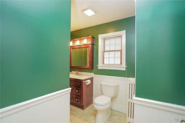 bathroom with toilet, vanity, and radiator