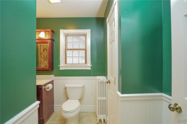 bathroom with toilet, vanity, tile patterned floors, and radiator heating unit