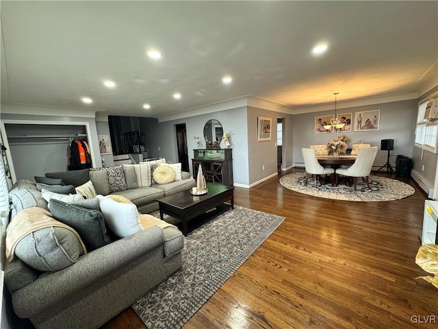 living room featuring dark hardwood / wood-style flooring, crown molding, and a chandelier