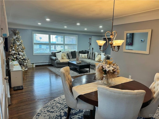 dining area featuring an inviting chandelier, baseboard heating, and dark hardwood / wood-style floors