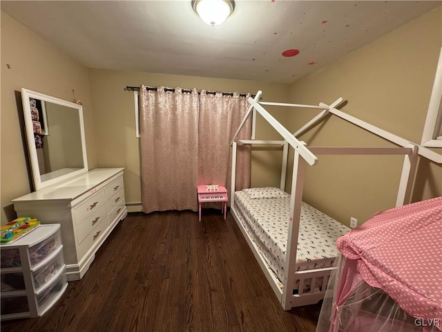 bedroom featuring baseboard heating and dark hardwood / wood-style flooring