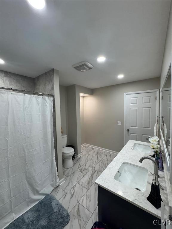 bathroom featuring toilet, vanity, and walk in shower