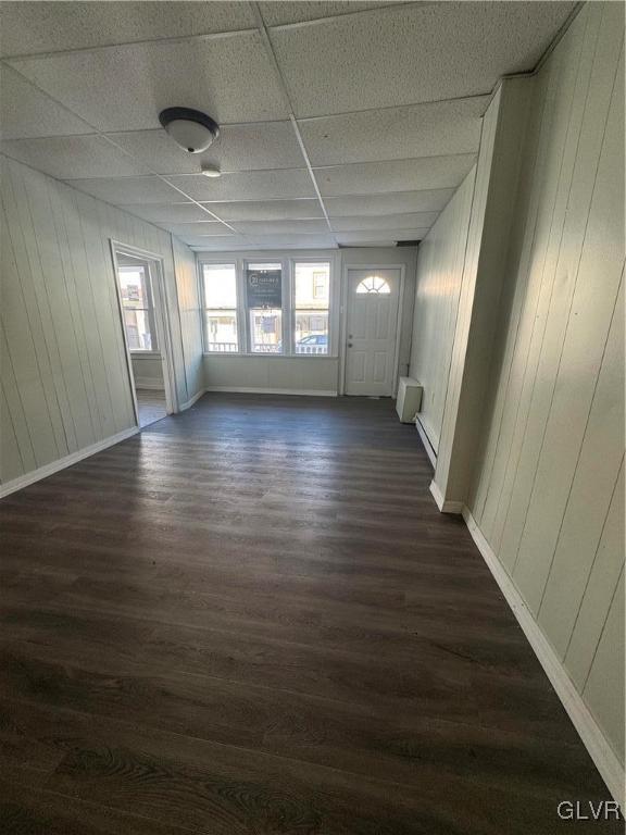 spare room featuring dark hardwood / wood-style flooring and a drop ceiling