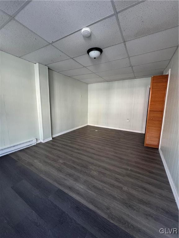 basement featuring a drop ceiling and dark hardwood / wood-style floors