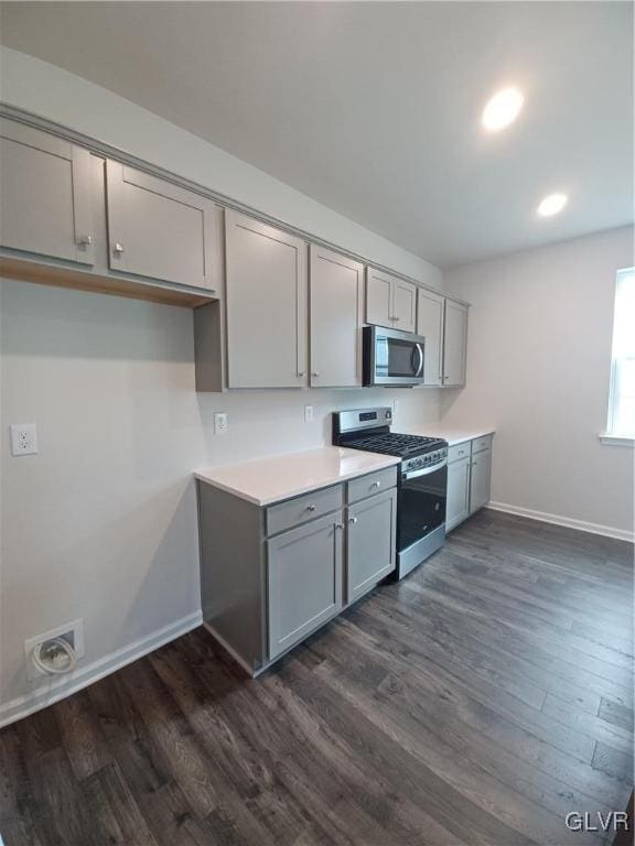 kitchen featuring dark wood-type flooring, appliances with stainless steel finishes, and gray cabinets