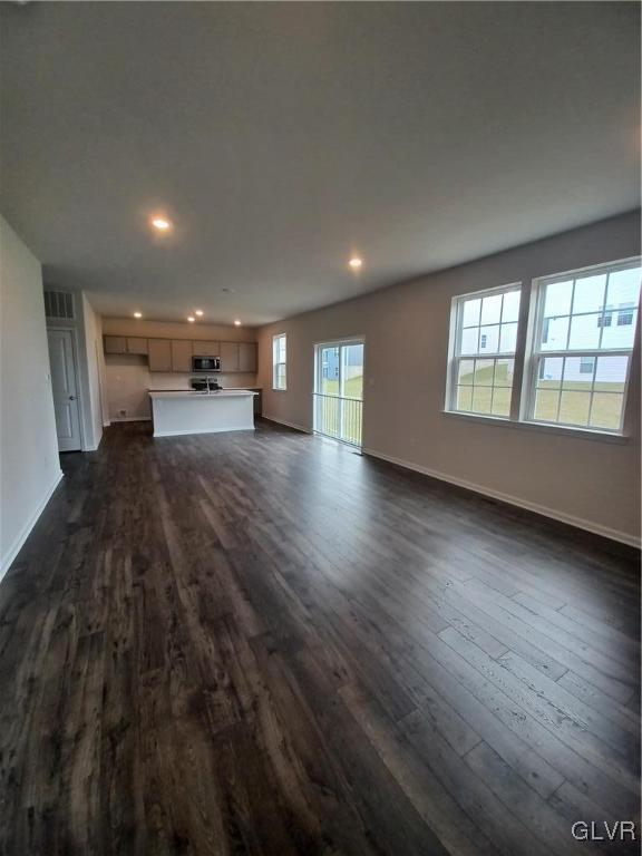 unfurnished living room featuring dark hardwood / wood-style floors