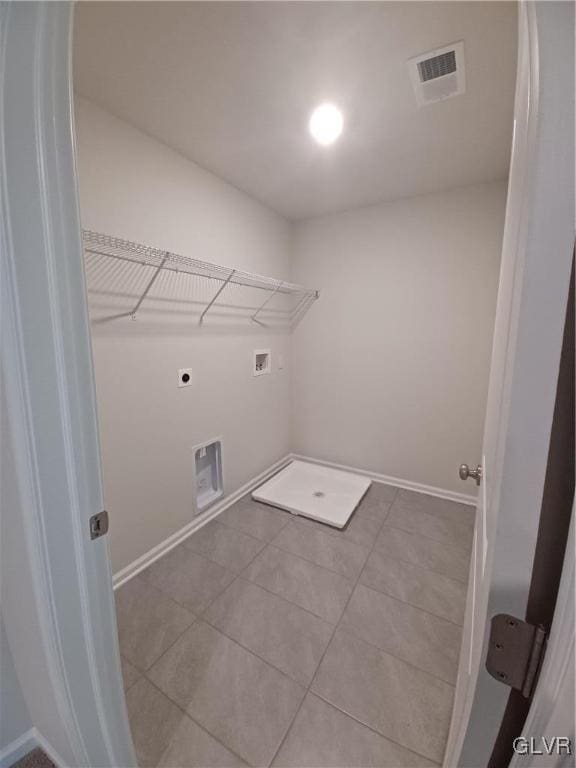 washroom featuring washer hookup, electric dryer hookup, and light tile patterned flooring