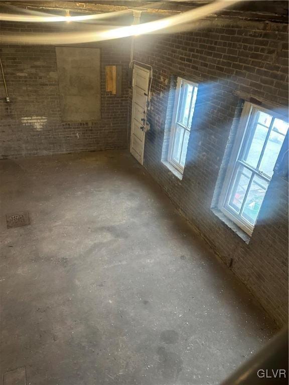 basement with brick wall and a wealth of natural light