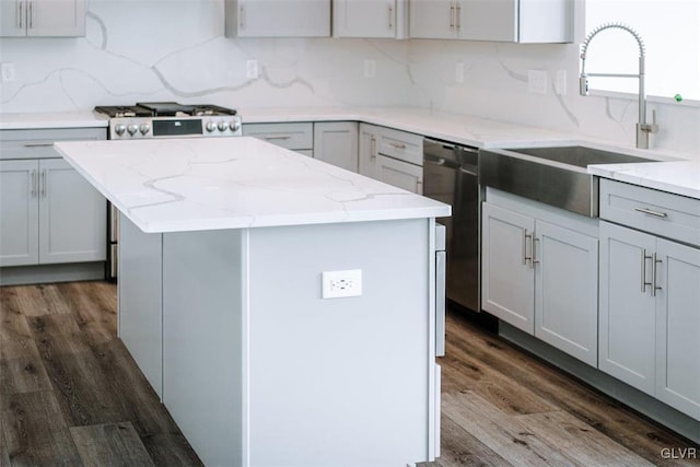 kitchen featuring tasteful backsplash, appliances with stainless steel finishes, dark wood-type flooring, and a center island