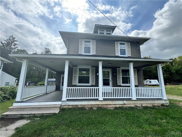 farmhouse inspired home with a front yard and covered porch