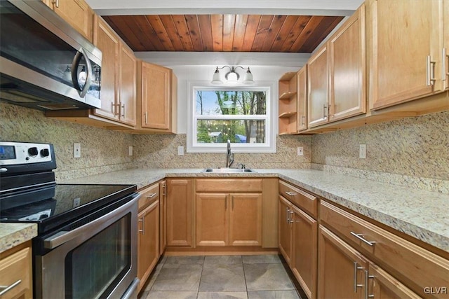 kitchen with light tile patterned floors, appliances with stainless steel finishes, decorative backsplash, light stone counters, and sink