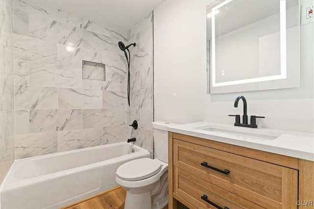 full bathroom with toilet, tiled shower / bath, wood-type flooring, and vanity