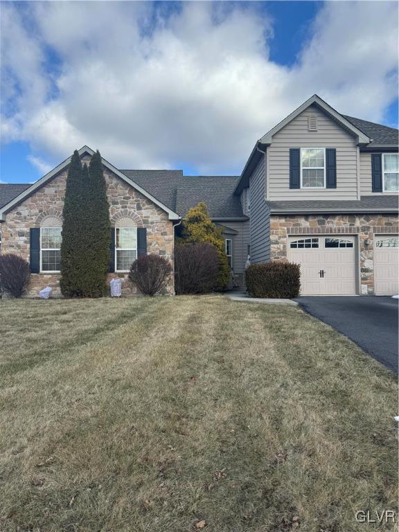 view of front of property with a front yard and a garage