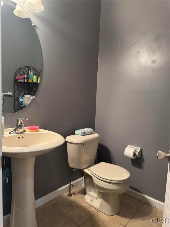 bathroom featuring sink, toilet, and tile patterned flooring