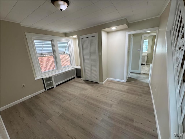 interior space featuring light wood-type flooring, a closet, and radiator