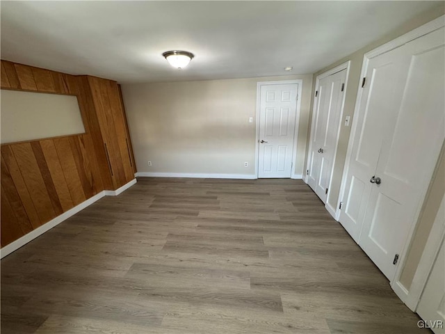 interior space featuring light hardwood / wood-style floors and wood walls