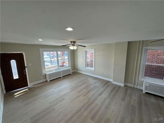 entrance foyer featuring ceiling fan, radiator, and light hardwood / wood-style floors