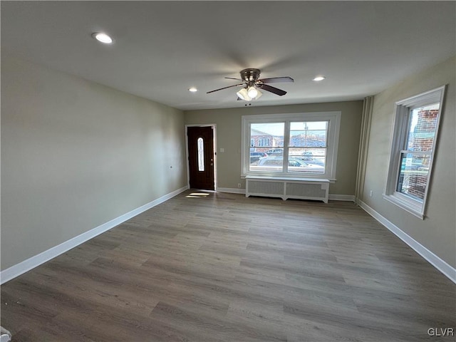 foyer entrance featuring ceiling fan, wood-type flooring, and radiator