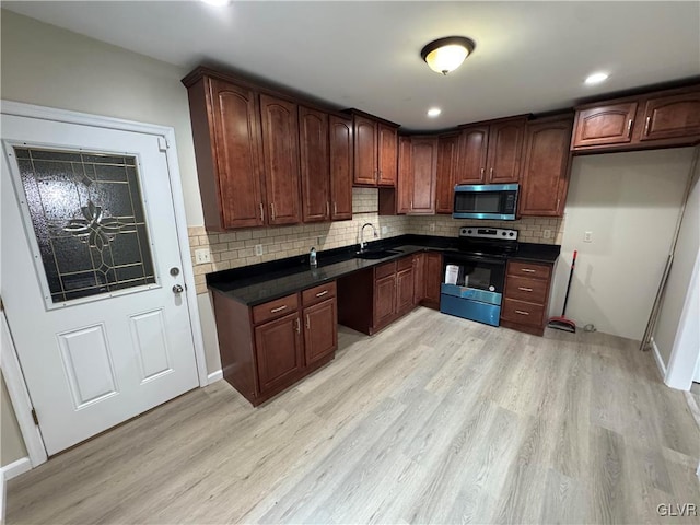 kitchen with light hardwood / wood-style floors, sink, decorative backsplash, and stainless steel appliances