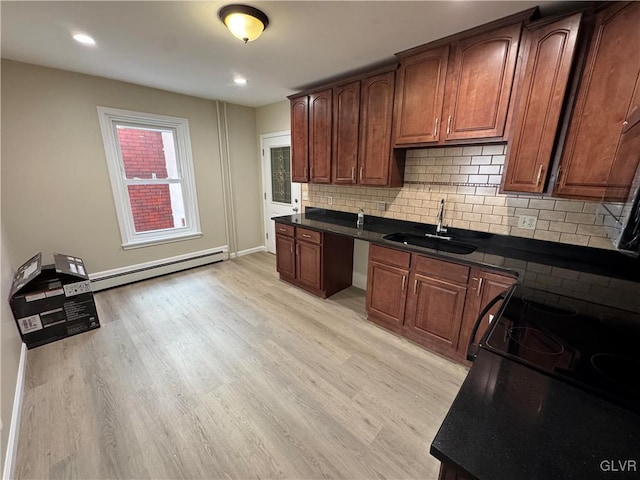 kitchen featuring sink, light hardwood / wood-style floors, backsplash, and a baseboard radiator