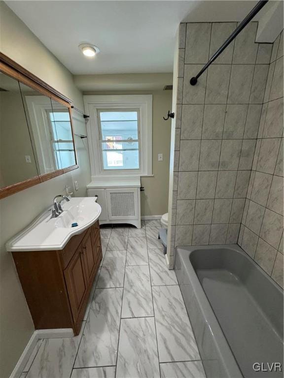 full bathroom featuring toilet, vanity, tiled shower / bath combo, and radiator heating unit