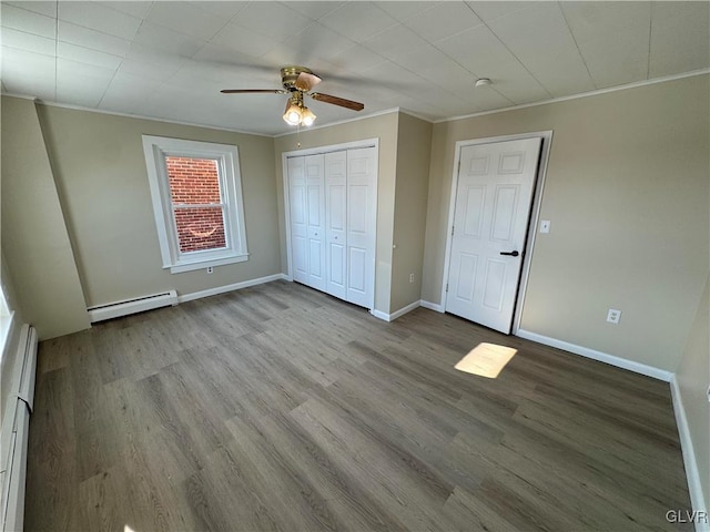 unfurnished bedroom featuring ceiling fan, a baseboard heating unit, light hardwood / wood-style flooring, and crown molding