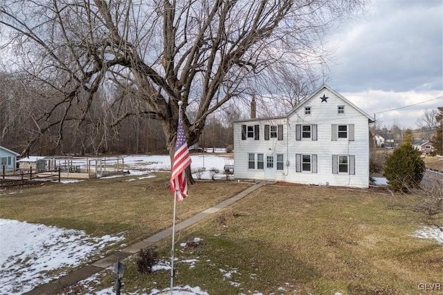 snow covered rear of property with a lawn