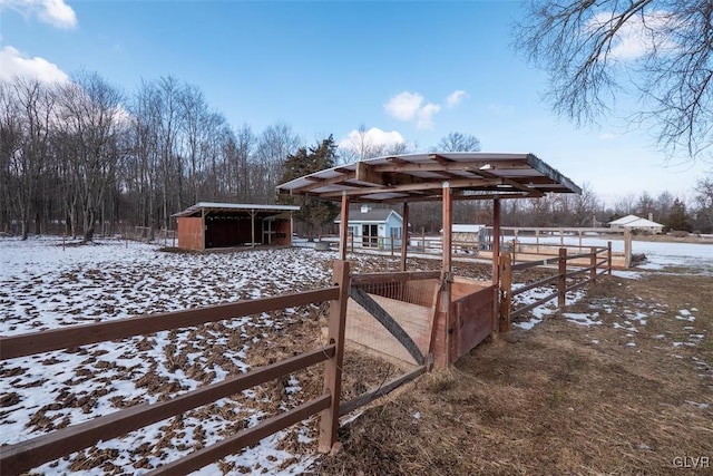 yard layered in snow featuring an outbuilding