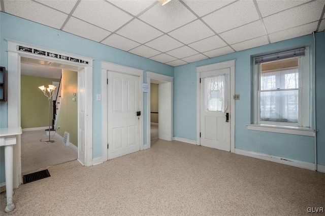 carpeted foyer featuring a chandelier