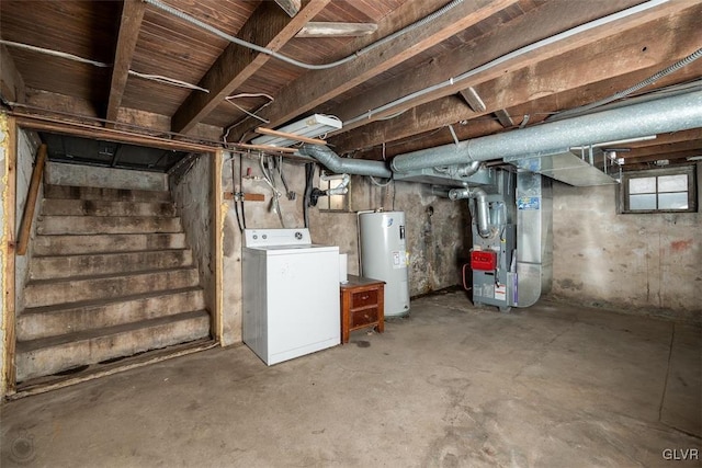 basement with electric water heater, washer / dryer, and heating unit